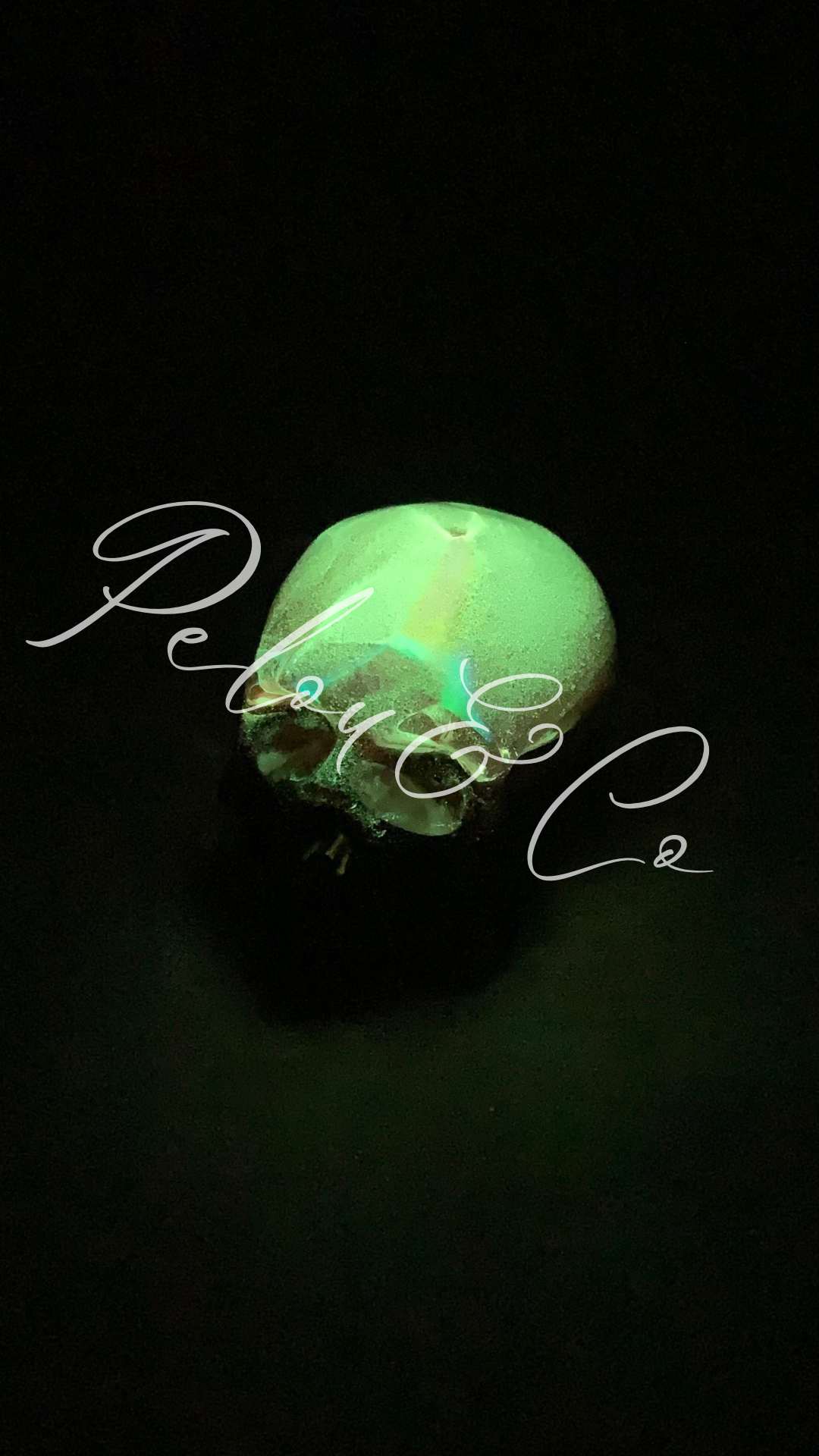 Objet décoratif artisanal petit crâne en résine époxy – feuille holographique + rose fluorescent nuit – fond noir Pelou&Co