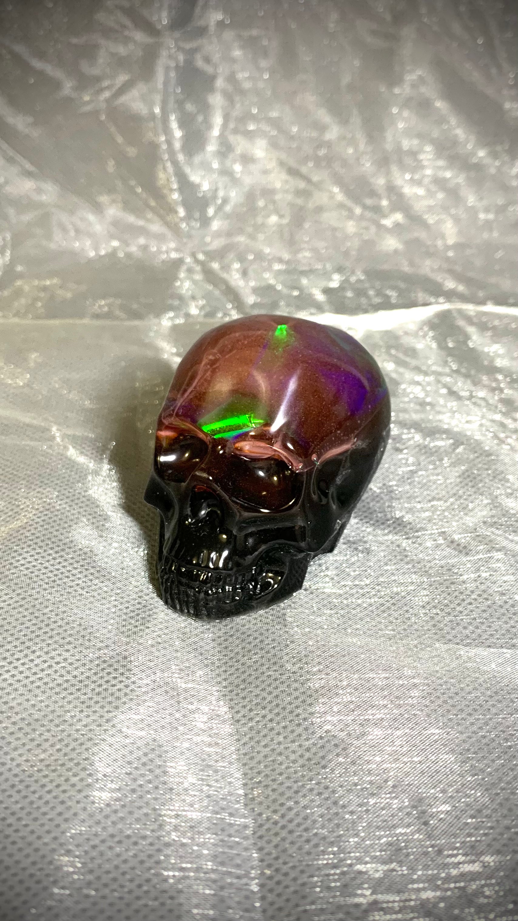 Objet décoratif artisanal petit crâne en résine époxy – feuille holographique + rose fluorescent nuit – fond noir Pelou&Co

