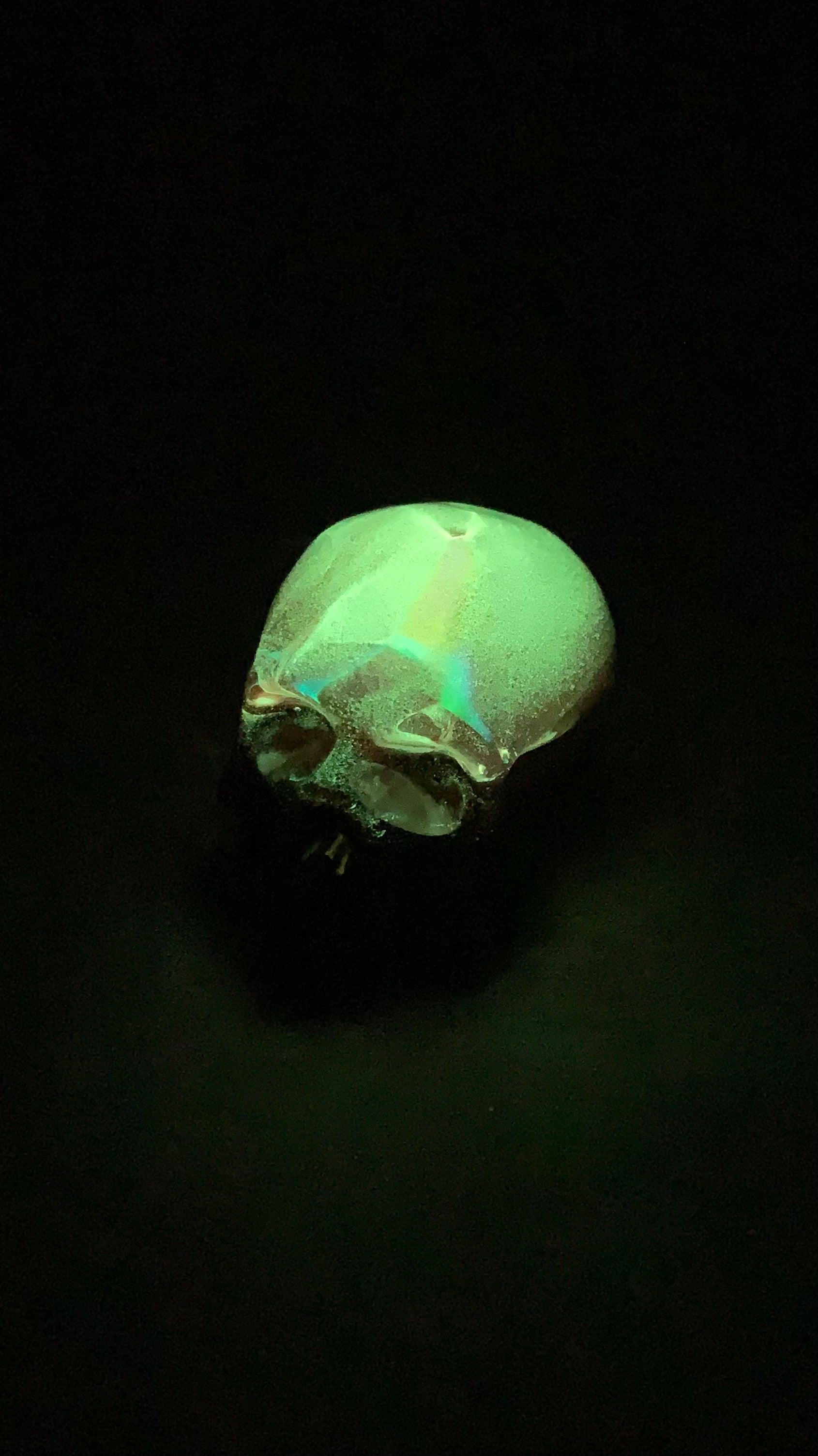 Objet décoratif artisanal petit crâne en résine époxy – feuille holographique + rose fluorescent nuit – fond noir Pelou&Co