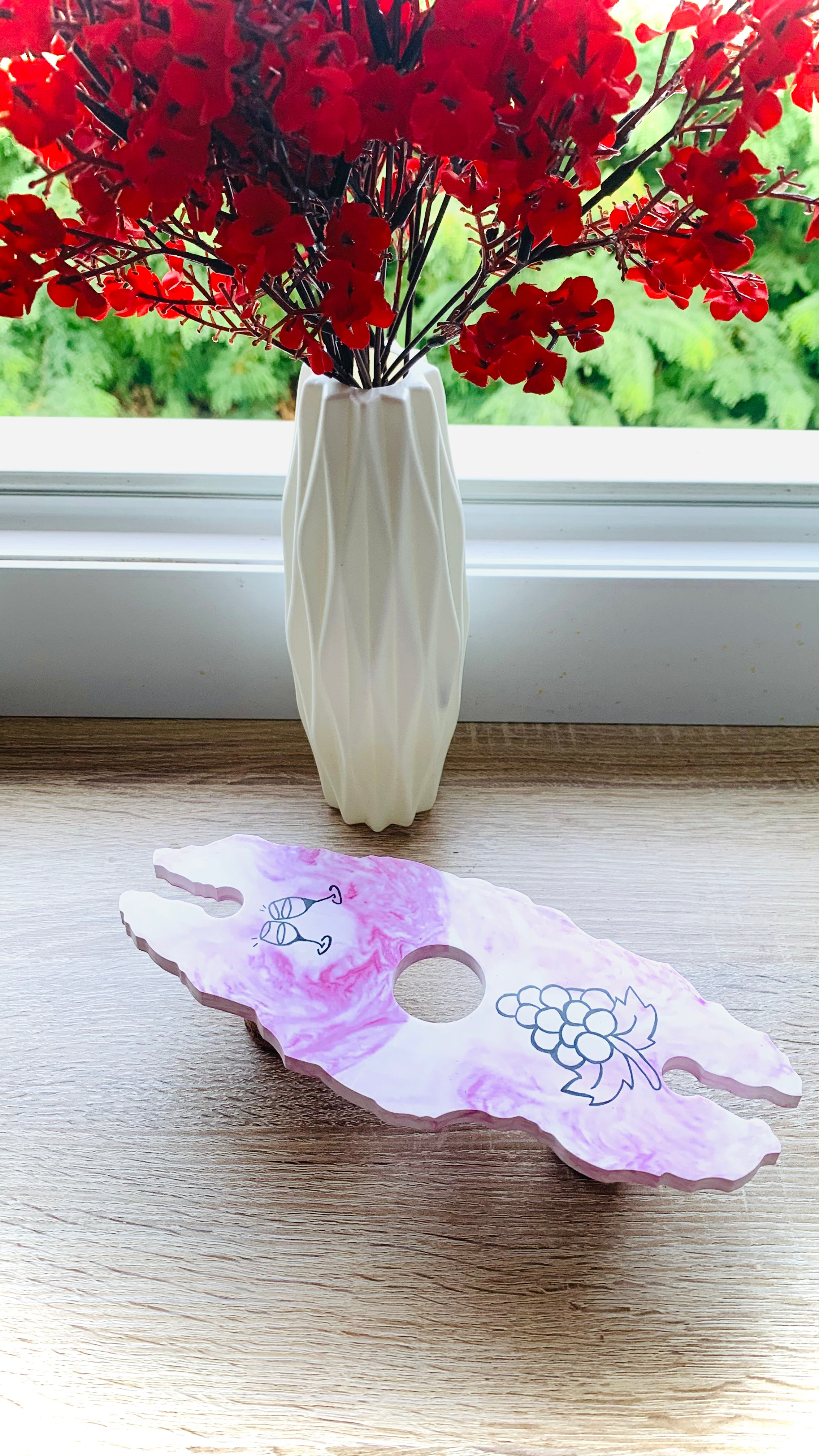 Porte-verre artisanal en résine minérale marbré rouge sur bouteille de vin, fait main en Corse.